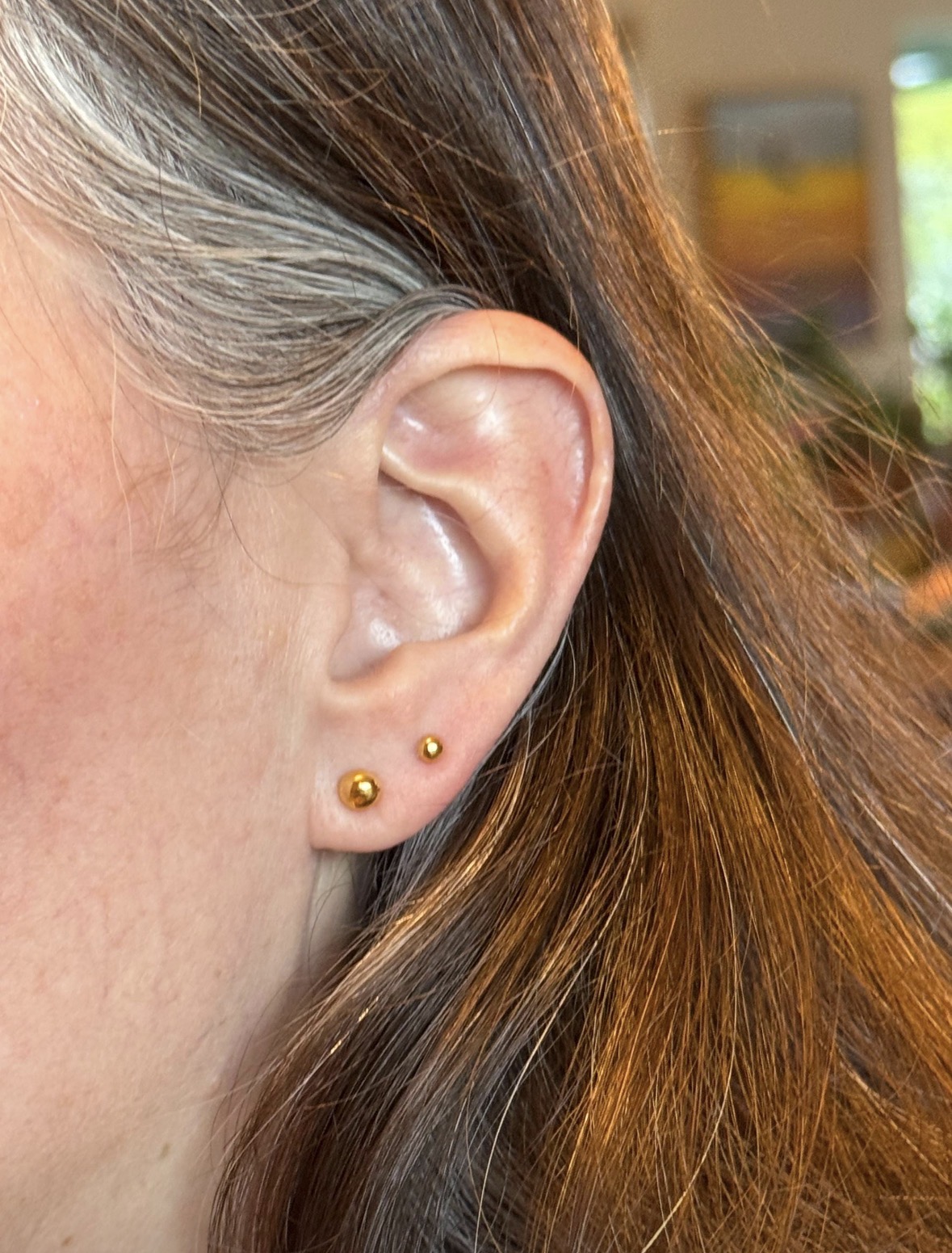 Customer wearing 24K gold ball stud earrings